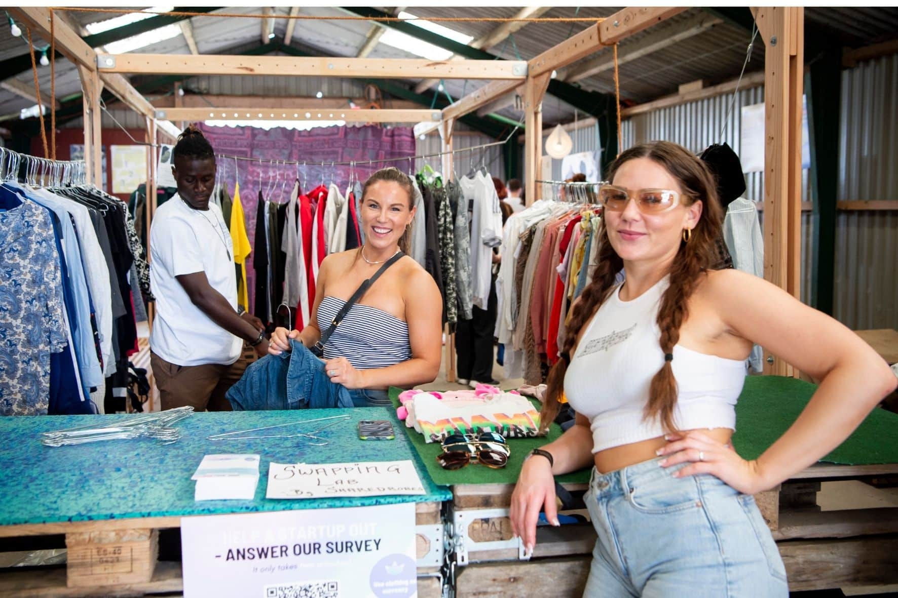 To personer køber genbrugt tøj i en bod på Roskilde festival for at være en del af den bæredygtige fremtid